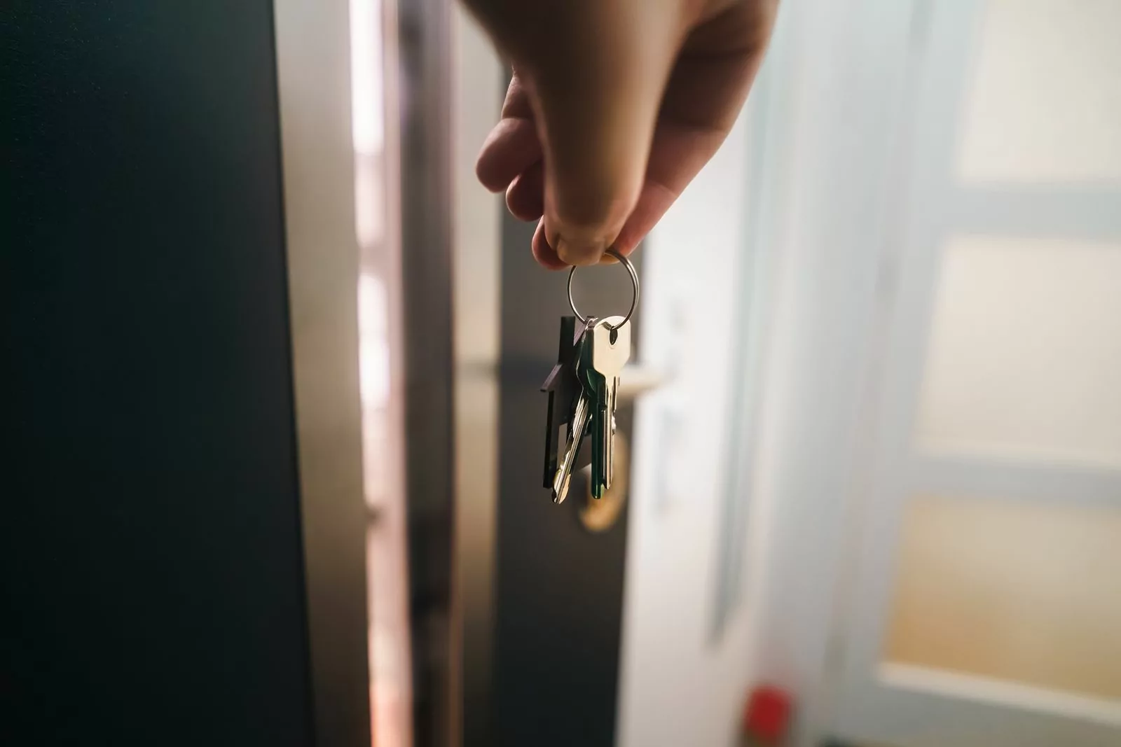 Client tenant ses clés devant la porte de son logement